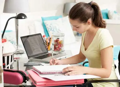 Alumna en un escritorio estudiando para el examen